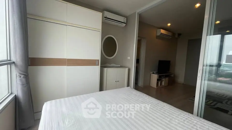 Modern bedroom with large window, air conditioning, and stylish wardrobe in a contemporary apartment.