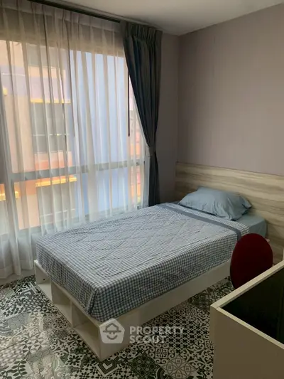 Cozy bedroom with large window and stylish flooring in modern apartment