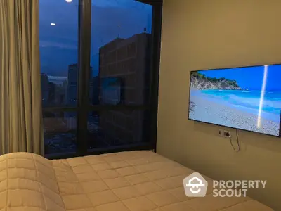 Modern bedroom with city view and wall-mounted TV in high-rise apartment