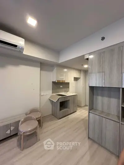 Modern compact kitchen with sleek cabinetry and integrated appliances in a stylish apartment.