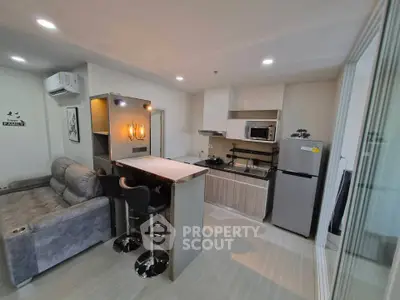 Modern open-layout kitchen and living room with stylish furniture and appliances.