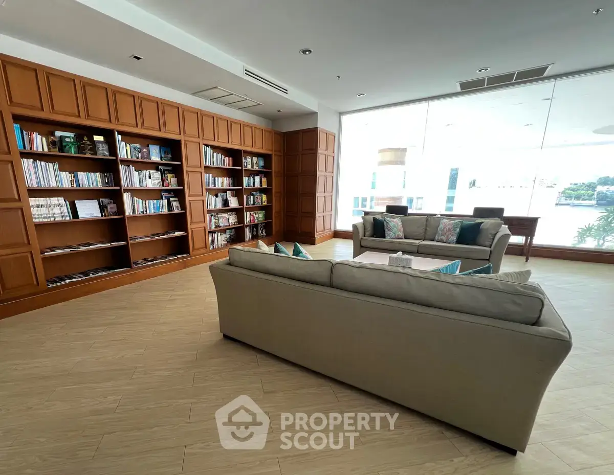 Elegant library with cozy seating and floor-to-ceiling bookshelves in a modern building.