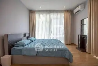 Spacious bedroom with modern decor and large window view