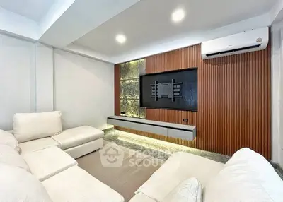 Modern living room with stylish wall paneling and cozy white sectional sofa.