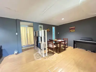 Spacious living room with dining area and piano, featuring modern decor and ample natural light.