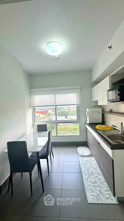 Modern kitchen with dining area and large window offering scenic views.