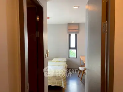 Cozy bedroom with twin beds and natural light, perfect for relaxation.