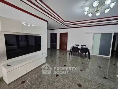 Spacious modern living room with elegant ceiling design and sleek furniture.