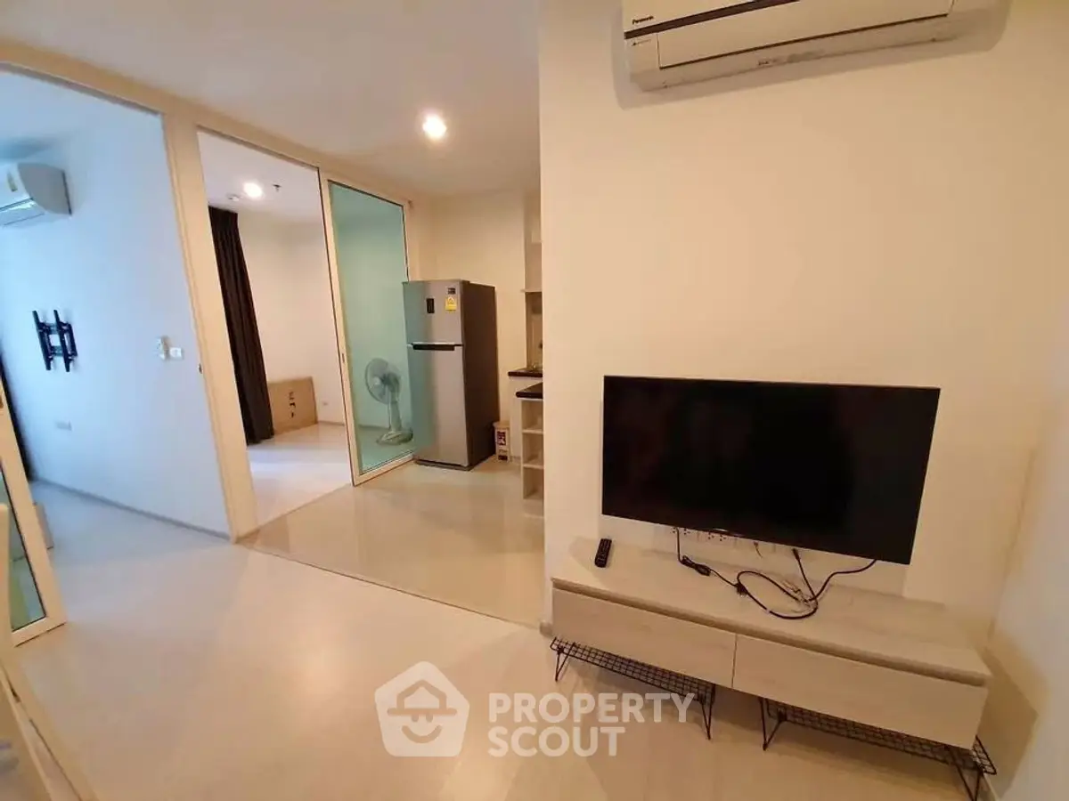 Modern apartment interior with air conditioning and sleek TV setup, featuring open layout and stylish flooring.
