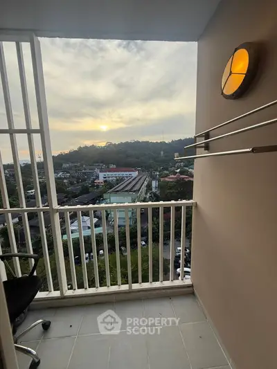 Charming balcony with scenic view of cityscape and hills at sunset.