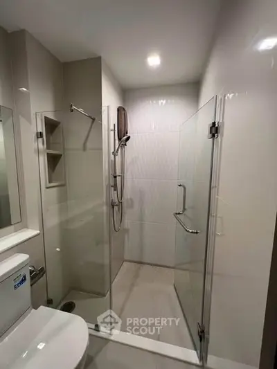 Modern bathroom with glass shower enclosure and sleek fixtures.