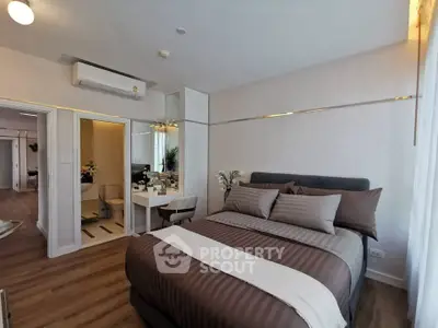 Modern bedroom with stylish decor and ensuite bathroom in a contemporary apartment.