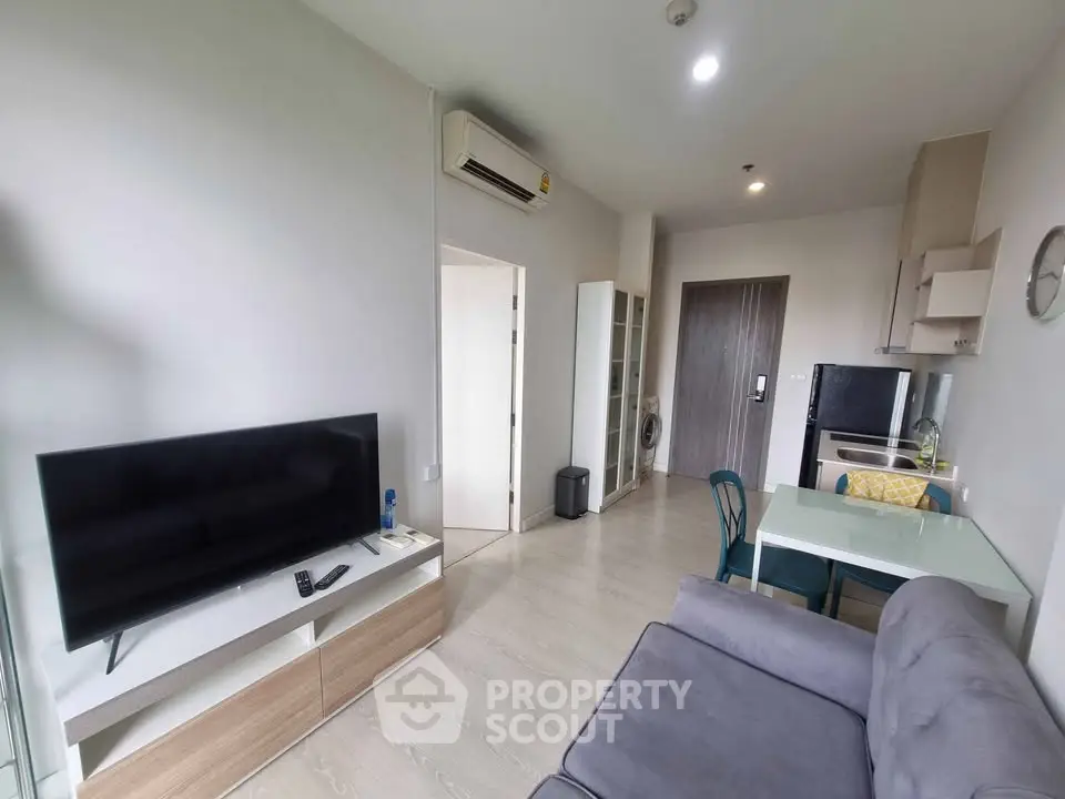 Modern living room with sleek furniture and open kitchen layout in a stylish apartment.