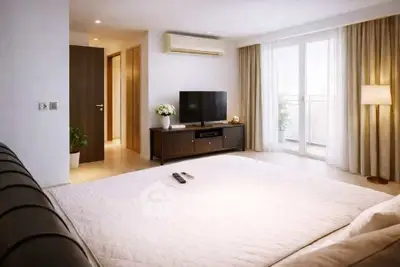 Spacious bedroom with modern decor and balcony access in luxury apartment.