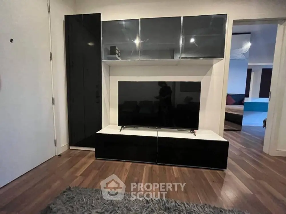 Modern living room with sleek black entertainment center and hardwood floors