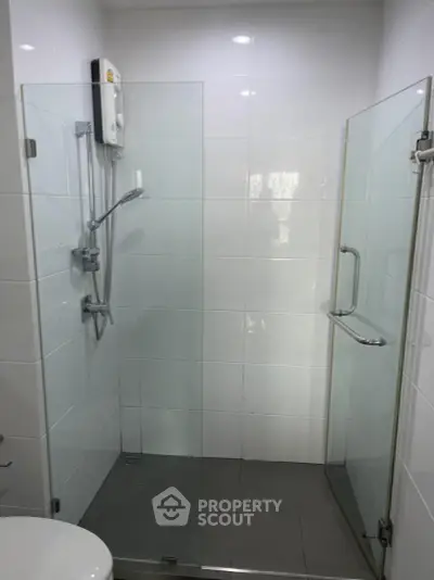 Modern bathroom with glass shower enclosure and sleek fixtures.
