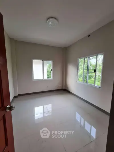 Bright empty room with large windows and glossy tiled floor, perfect for customization.