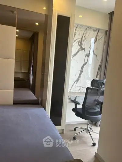 Modern bedroom with stylish study area and marble accent wall, perfect for urban living.