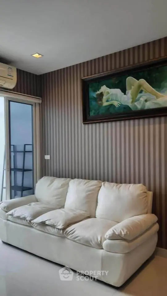 Stylish living room with plush white sofa and elegant wall art, perfect for modern urban living.