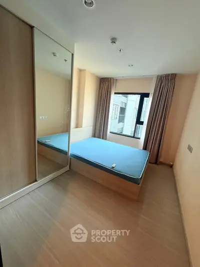 Modern bedroom with large mirror wardrobe and natural light from window