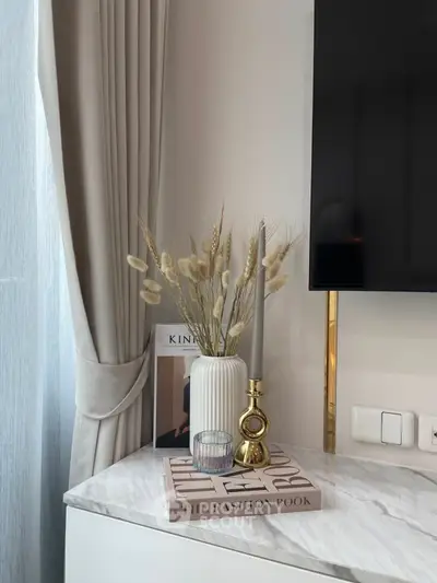 Elegant interior decor with marble top, vase, and modern TV setup.