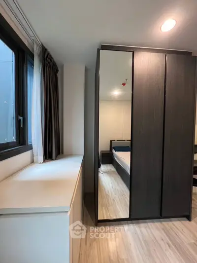 Modern bedroom with sleek wardrobe and large window for natural light