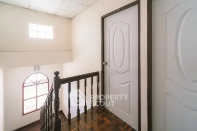 Charming interior hallway with wooden railing and natural light