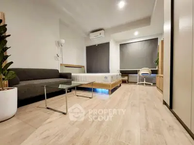 Modern studio apartment with sleek design and cozy furnishings, featuring a comfortable bed and stylish decor.