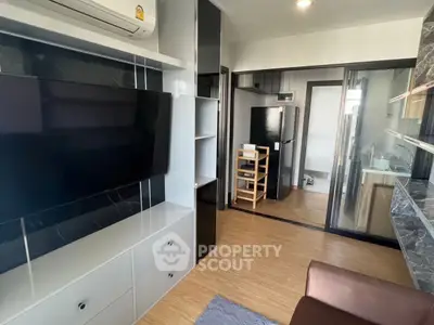 Modern living room with sleek TV setup and open kitchen view