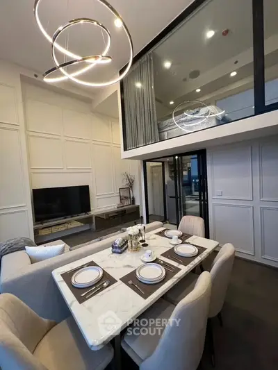 Modern duplex living room with elegant dining area and stylish lighting fixtures.