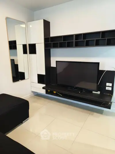 Modern living room with sleek black and white entertainment unit and wall-mounted TV.