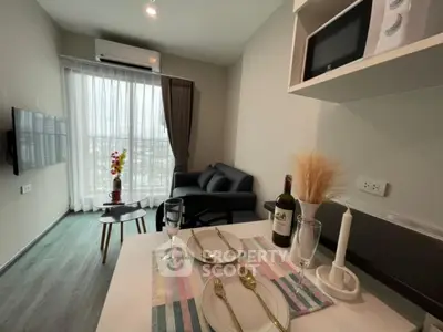 Modern living room with dining area, featuring sleek furniture and natural light from large windows.