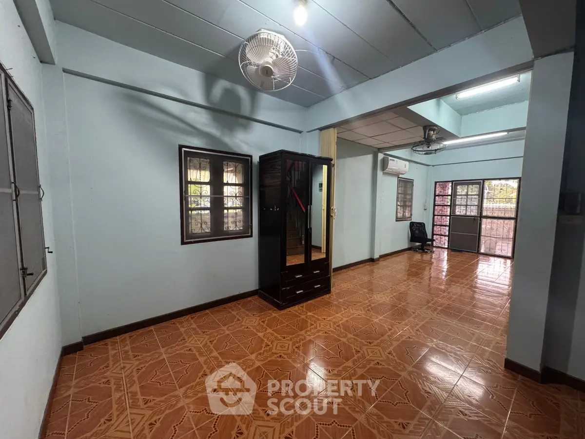 Spacious interior with tiled flooring and ceiling fan, ideal for versatile living space.