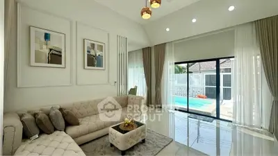 Luxurious living room with pool view, elegant decor, and modern furnishings.