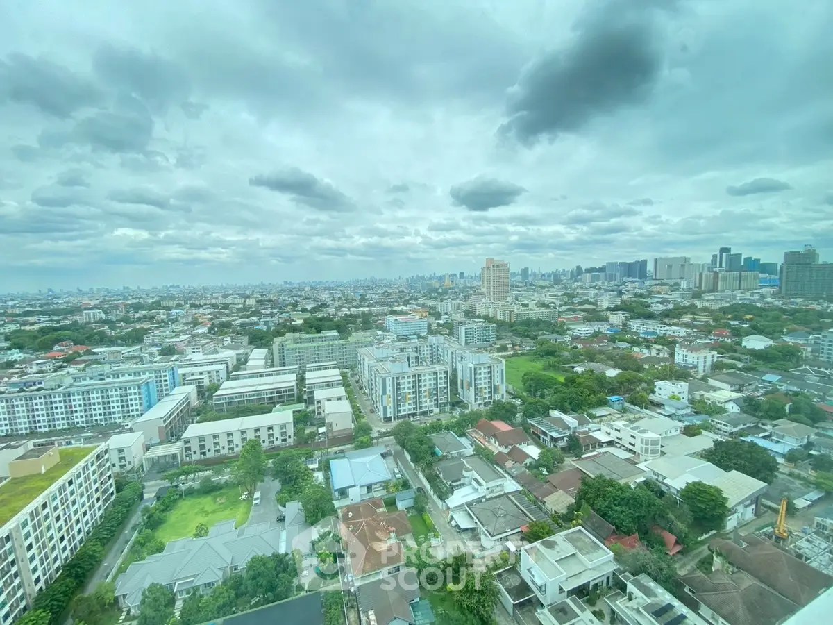 Stunning panoramic cityscape view from high-rise apartment, showcasing urban skyline and lush greenery.