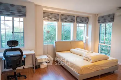 Bright bedroom with large windows and modern furniture, perfect for relaxation and productivity.