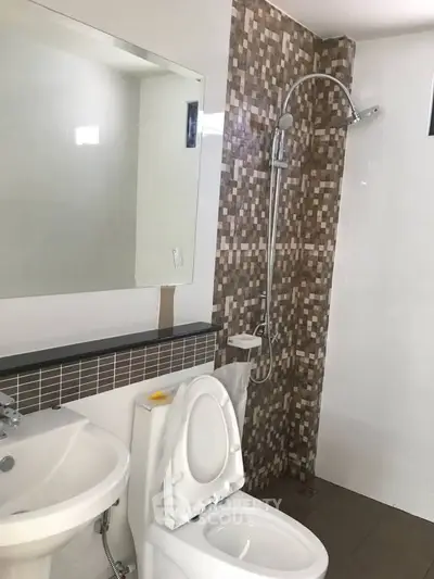Modern bathroom with mosaic tile shower and sleek fixtures