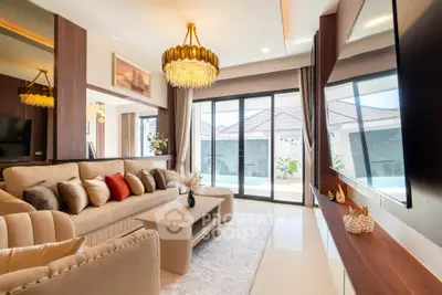 Luxurious living room with elegant decor and pool view, featuring plush seating and modern lighting.