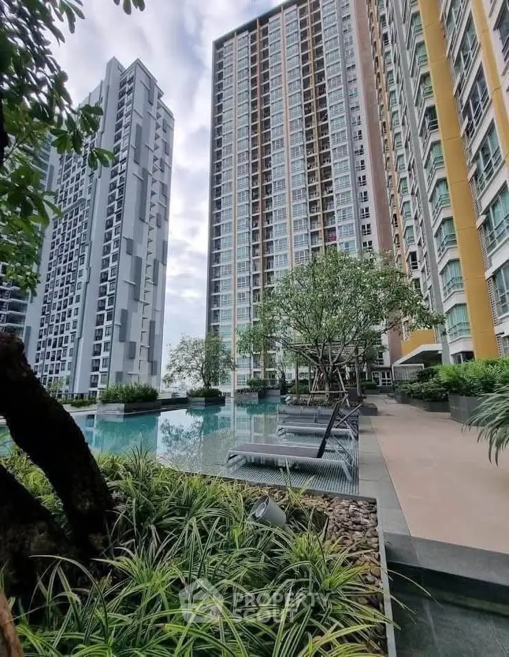 Luxurious high-rise residential complex with pool and lush landscaping