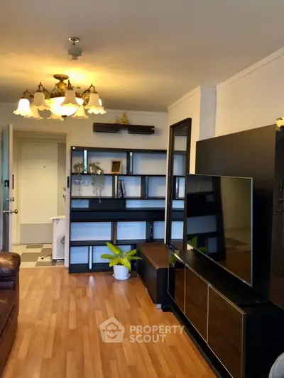 Spacious living room with modern decor and large TV, perfect for relaxation and entertainment.