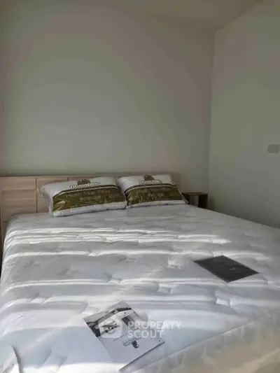 Cozy bedroom with a neatly made bed and soft lighting, perfect for relaxation.