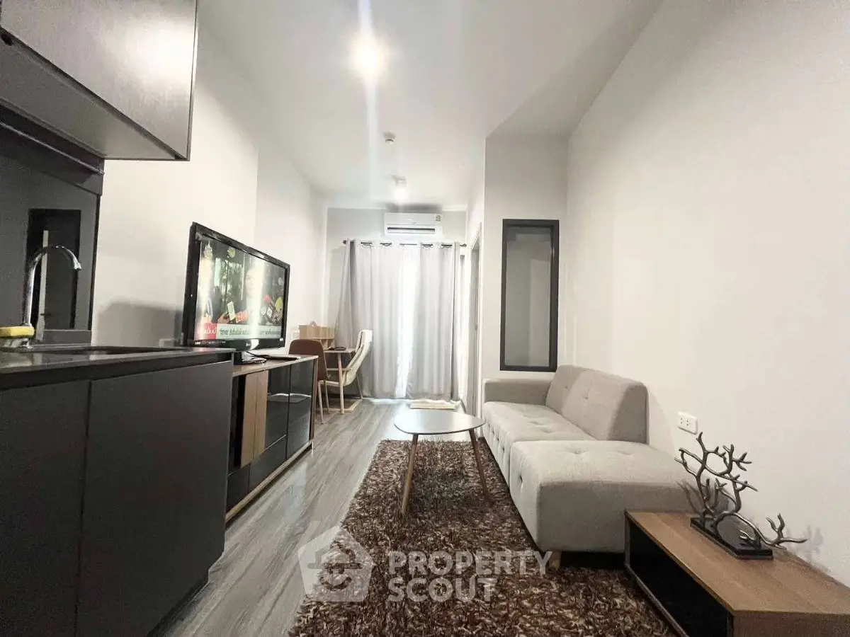 Modern living room with sleek furniture and open kitchen layout in a stylish apartment.