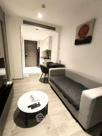 Modern living room with sleek furniture and open kitchen layout in a stylish apartment.