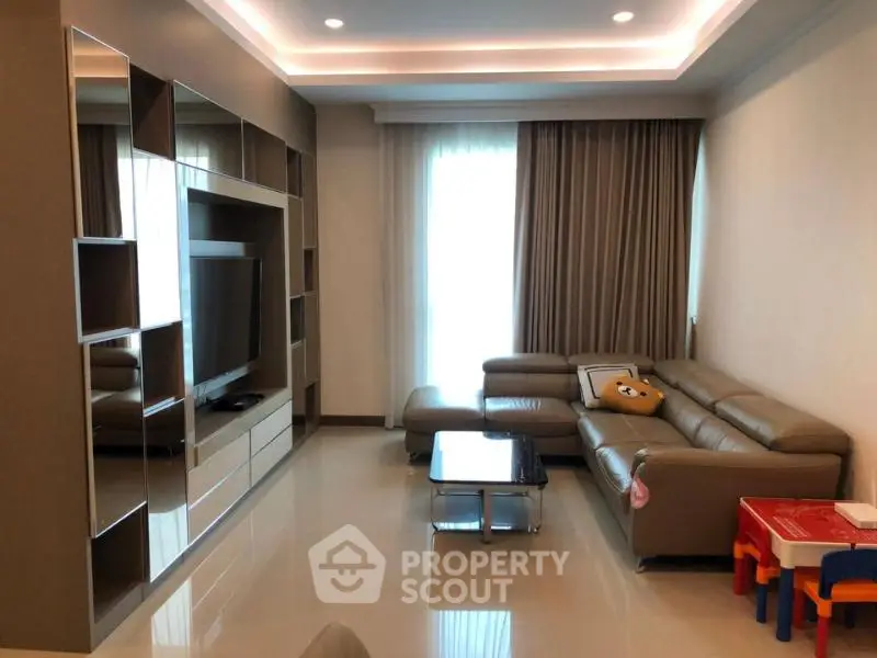 Modern living room with sleek furniture and large TV unit, perfect for family gatherings.