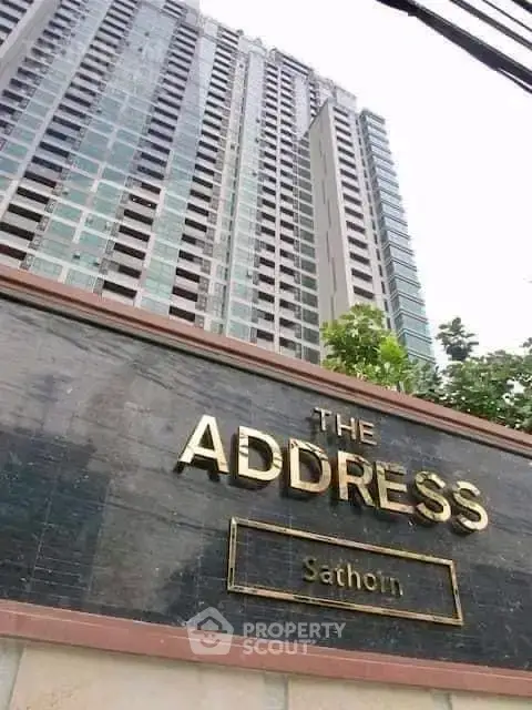 Modern high-rise building exterior with prominent signage at The Address Sathorn.