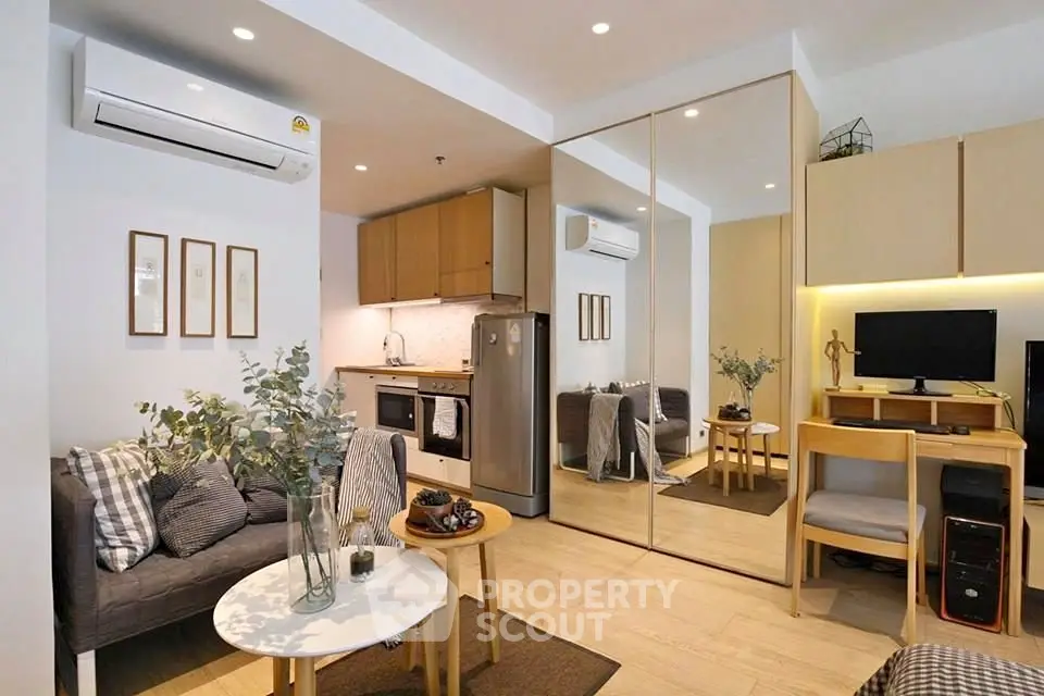 Modern living room with open kitchen, stylish decor, and mirrored wardrobe