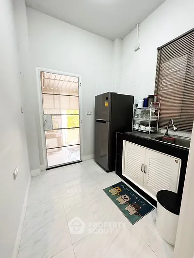 Modern kitchen with sleek appliances and access to outdoor patio, perfect for entertaining.