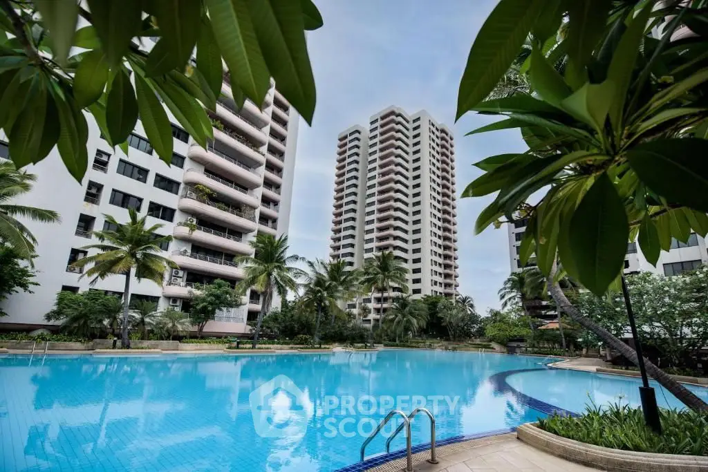 Luxurious high-rise apartments with a stunning pool and lush greenery, perfect for modern living.
