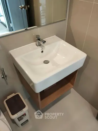 Modern bathroom with sleek sink and mirror in a contemporary home.