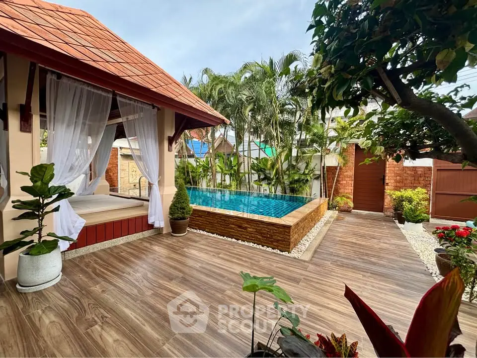 Luxurious outdoor pool area with tropical landscaping and elegant wooden deck, perfect for relaxation and entertainment.